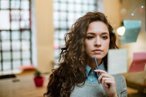 Young woman pondering some notes