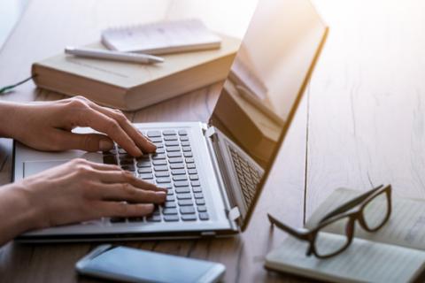 Hands writing on a laptop