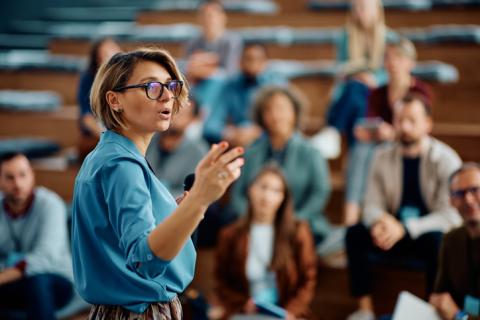 A woman speaks to a group of a people