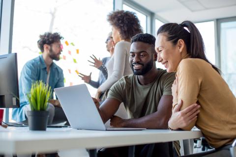 Multiracial group working at laptop