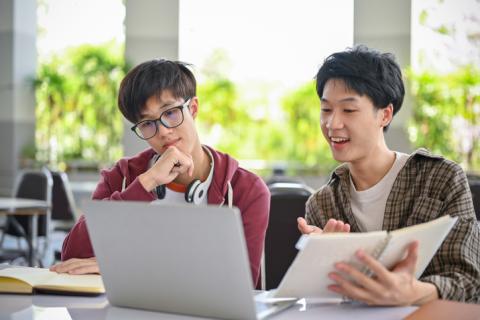 Two male Asian students working together