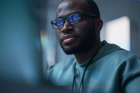 Black man looking at computer screen