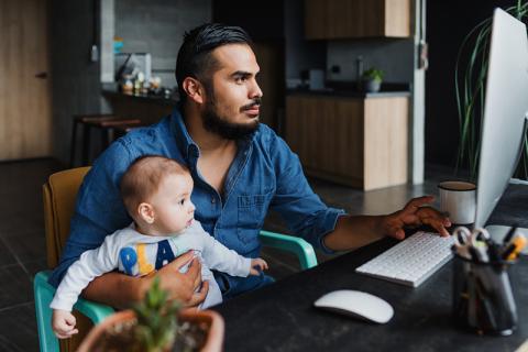 Latin American father working from home with toddler