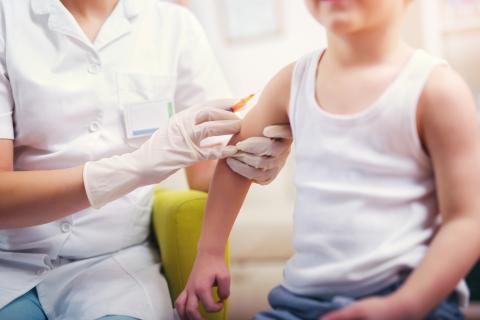 Boy receives immunisation from medical professional.