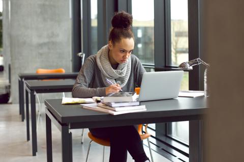 Student writing in library