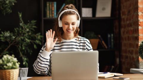 A cheerful student waves hello on a Zoom call