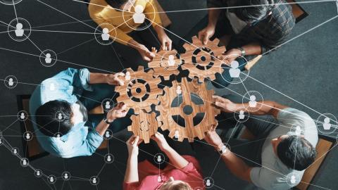 People sat around a table slotting cogs together