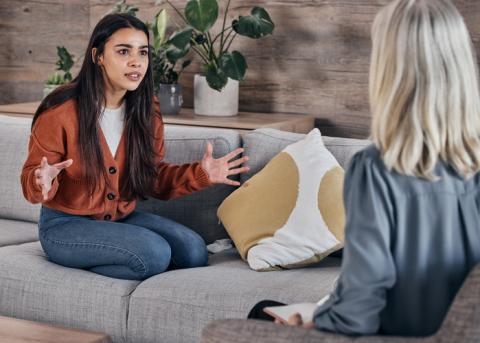 A young woman talks to a therapist earnestly