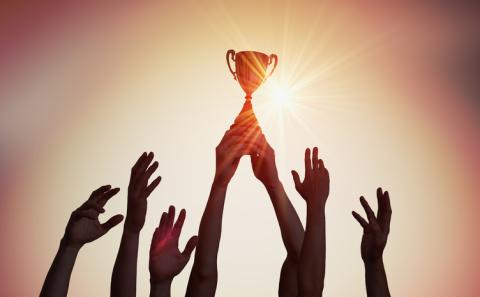 Hands hold a trophy aloft
