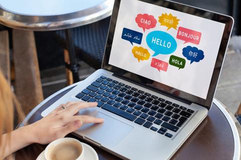 Different languages in speech bubbles on a laptop
