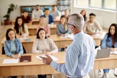 A teacher at the front of a class full of students
