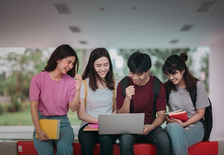 Students gathered around a laptop