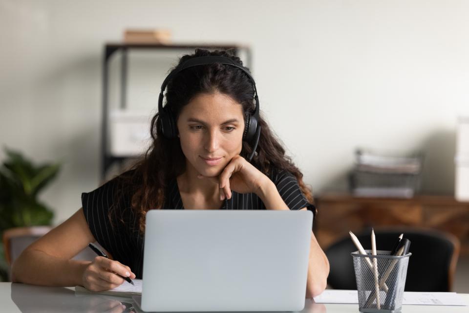 A student at her laptop with earphones on