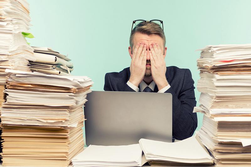 Man sitting among piles of papers