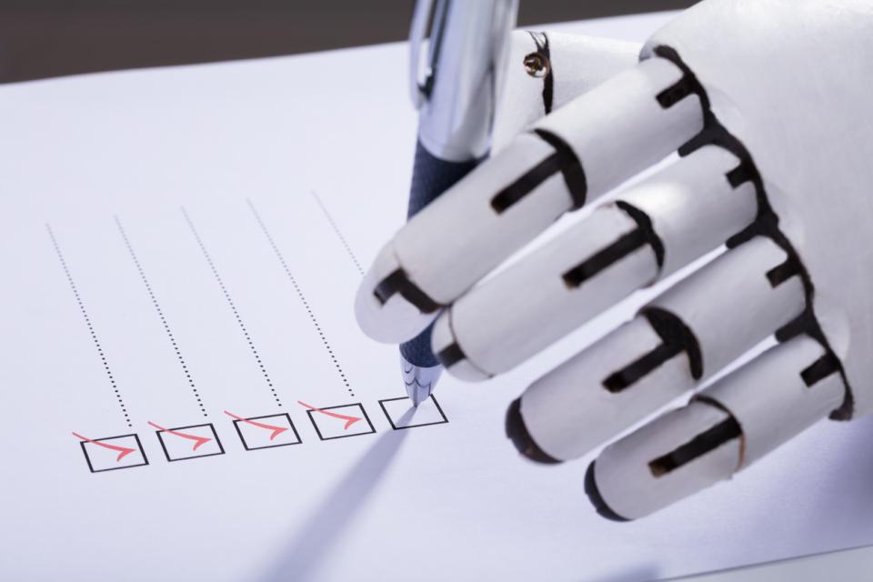 A robot hand ticking check boxes on a piece of paper