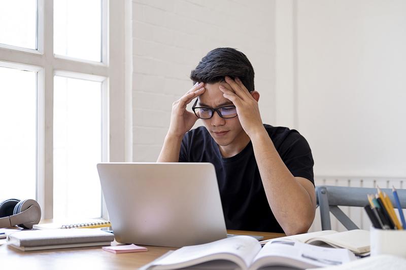 Asian student concentrating on laptop