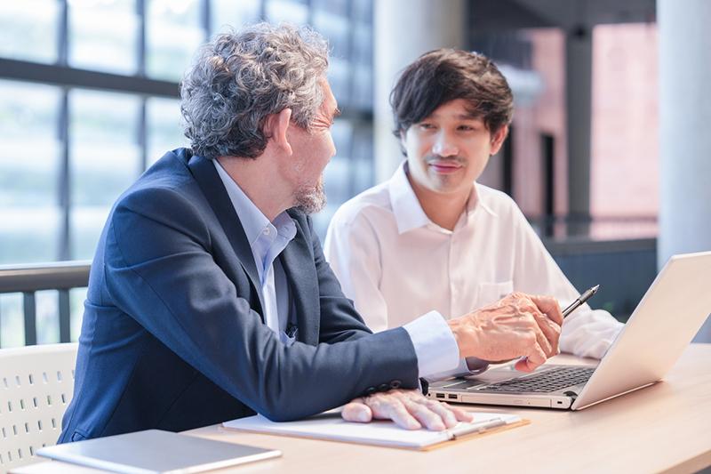 Professor talking to male Asian student