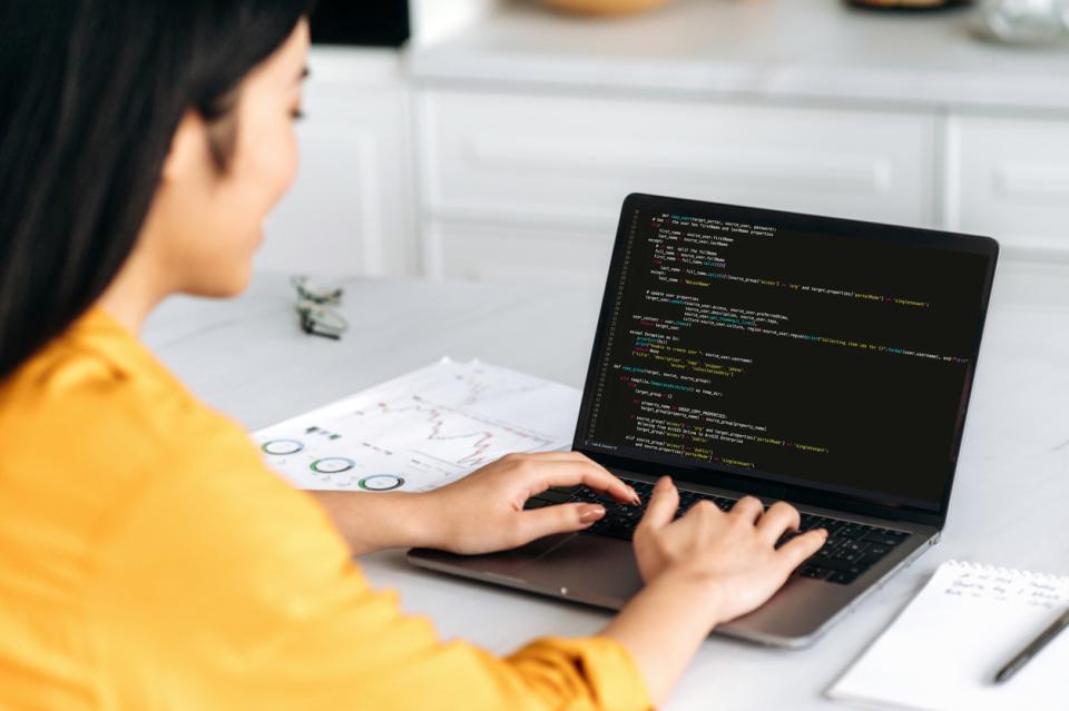 A computer programming student working on her laptop 