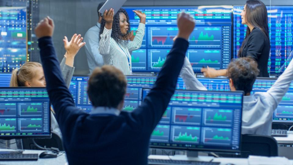 Traders at their computers celebrating