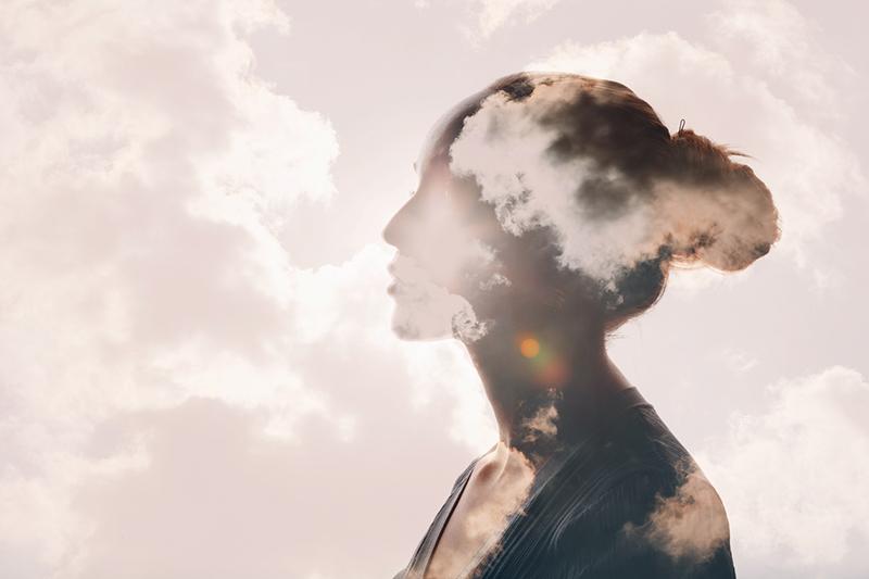Woman with head in clouds, calm concept