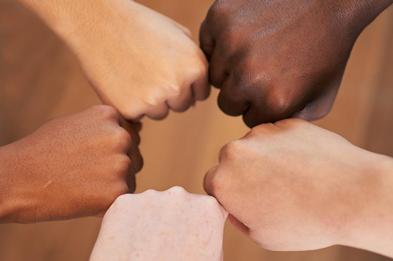 Multiracial hands in fist bump circle