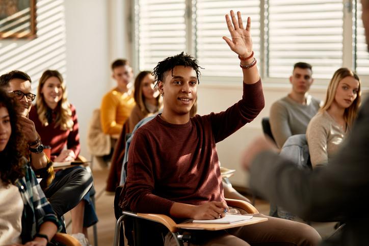 A student raises a hand in a classroom