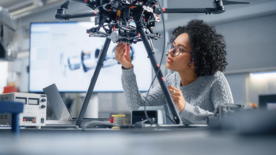A Black woman engineer building a robot