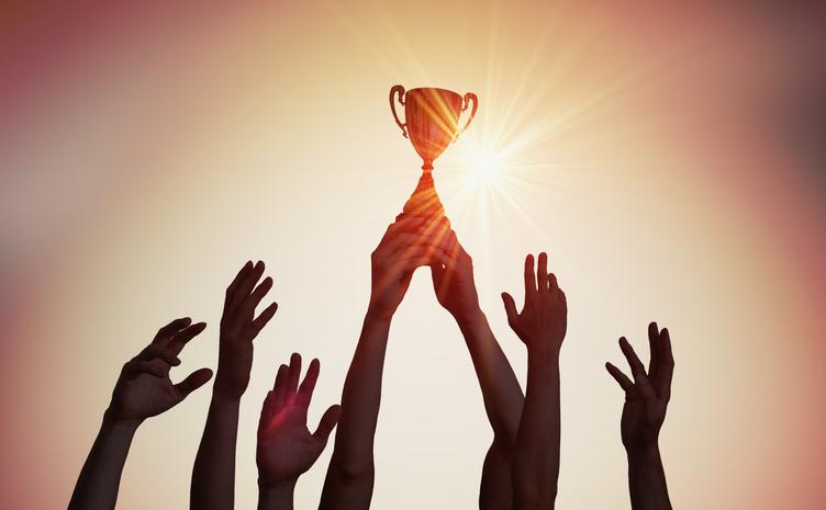 Hands hold a trophy aloft