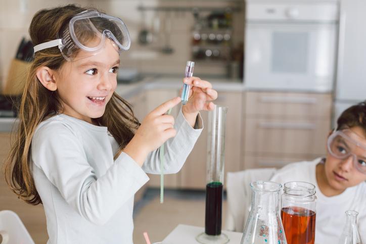 A small girl points to a test tube