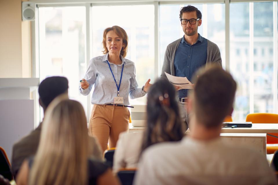 Two teachers at the front of a class full of students