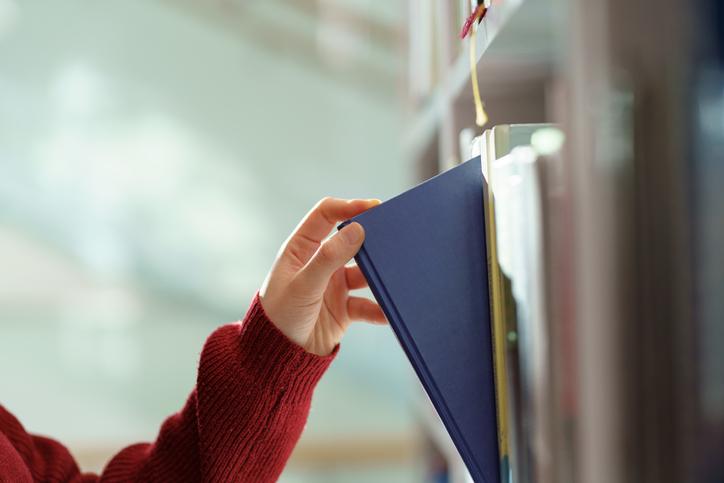 A library book being removed from a shelf