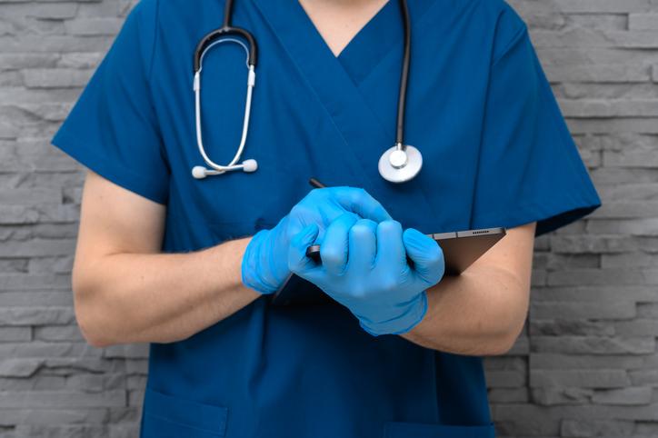 A doctor takes notes on a clipboard