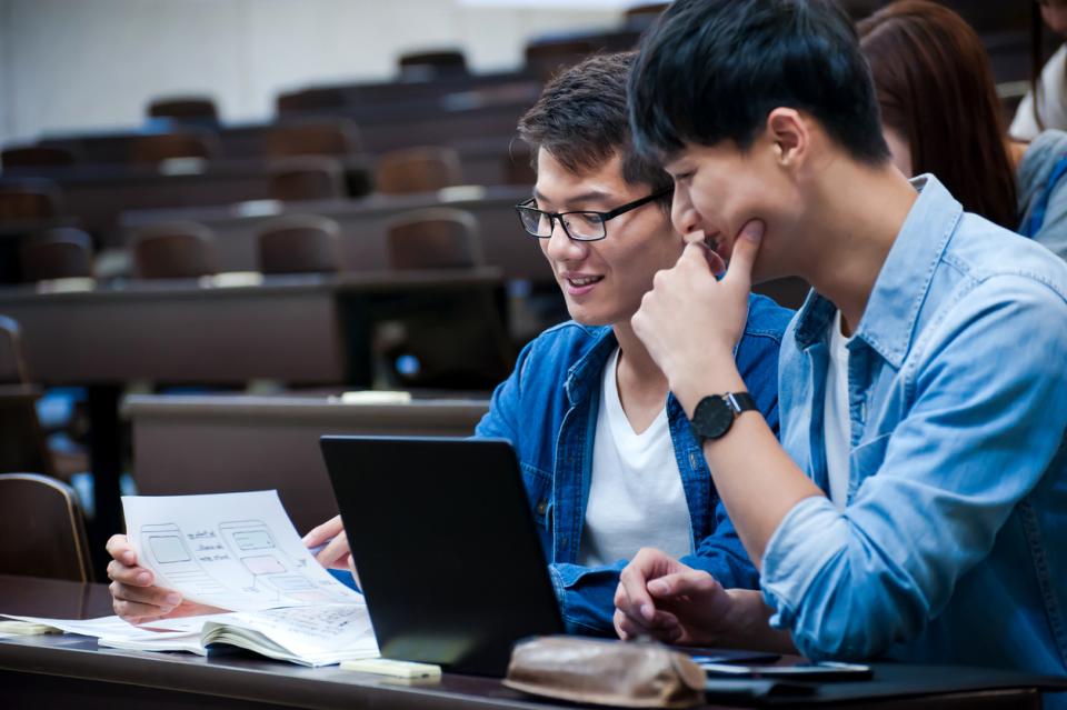 Two language students reading a physical document