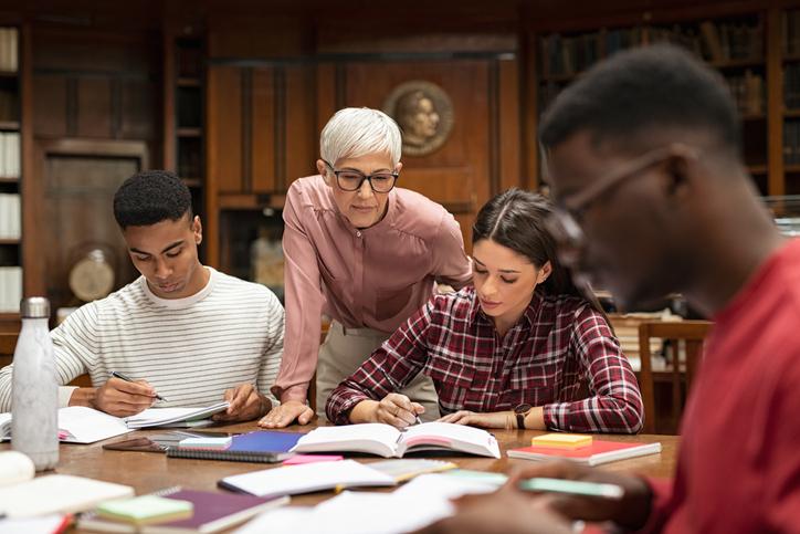A lecturer observes her students reading