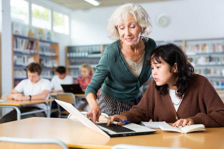 An educator helps a student in class