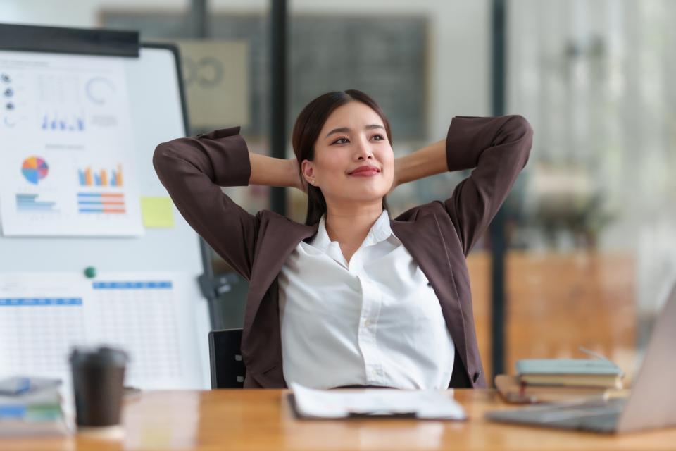 A woman looking relaxed sitting at her desk