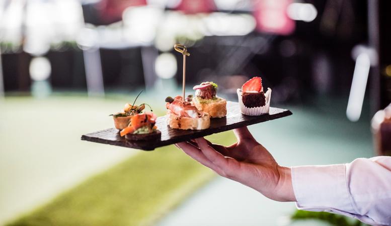 Bite-sized canapes are presented on a slate