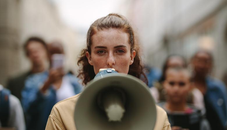 A woman holds a megaphone at a protest