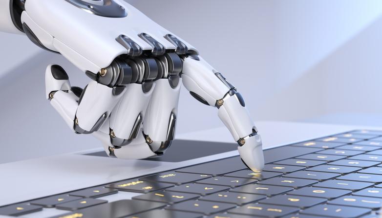 A robot hand presses a key on a laptop keyboard