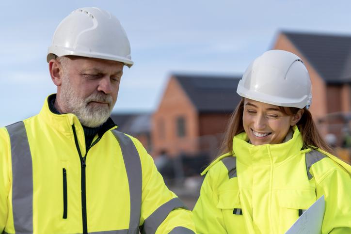 Workers in hard hats and hi-vis discuss their plans