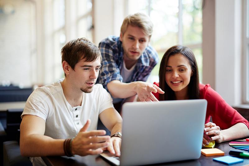 Young male teaching assistant with two college students