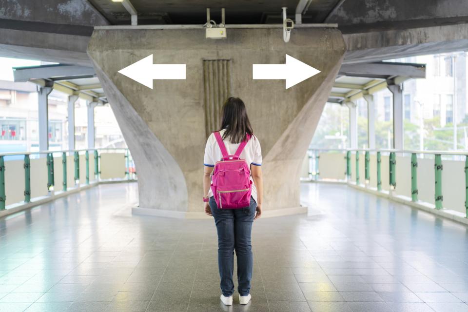 Someone standing at a crossroad, unable to make a decision