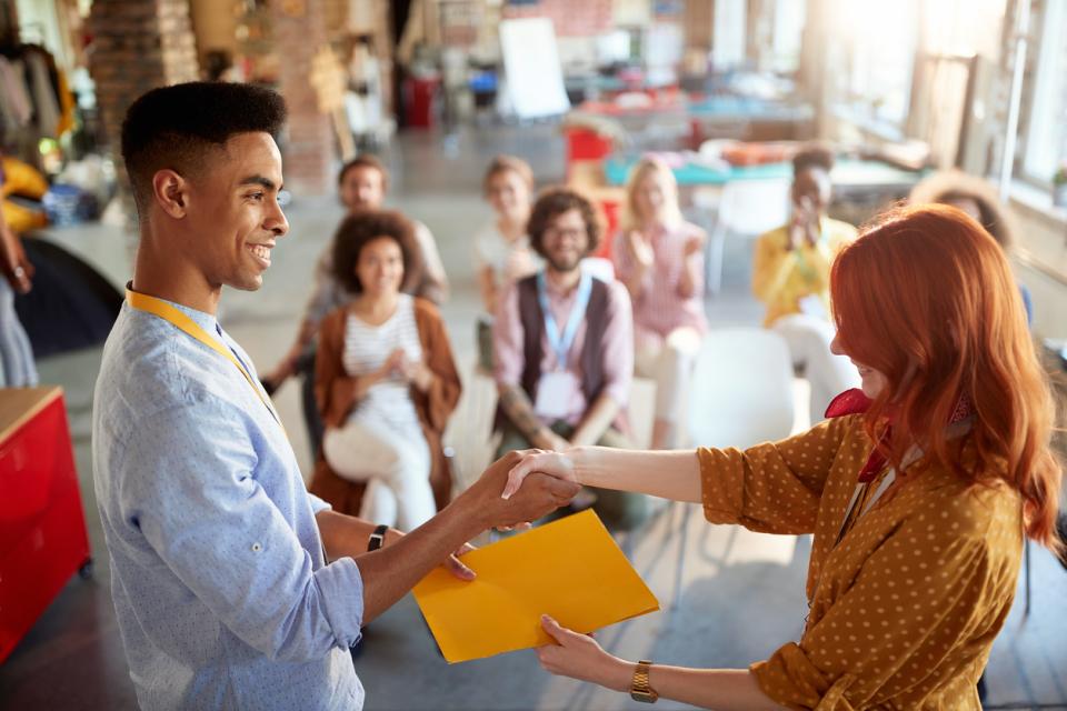 A teacher accepting an award in front of colleagues
