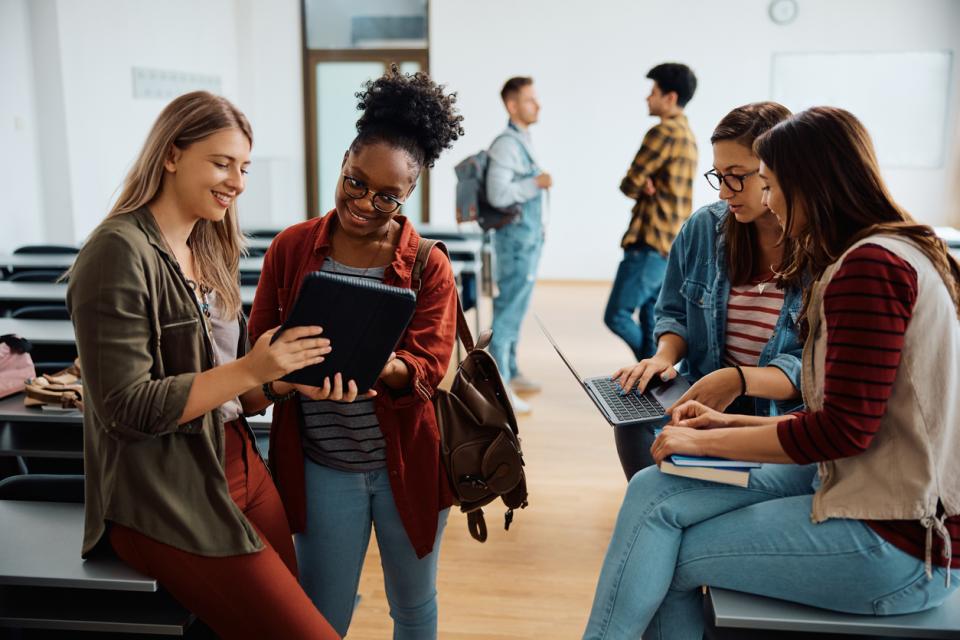 A group of students discussing something on an iPad