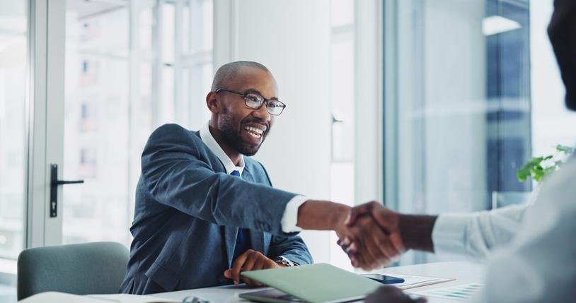 A candidate shakes hands with an interviewer