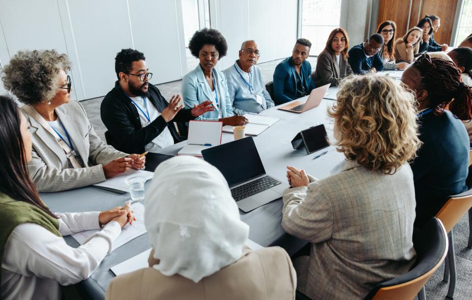 Employees sitting at a long table in a boardroom
