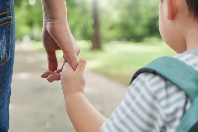Mother holding small child’s hand
