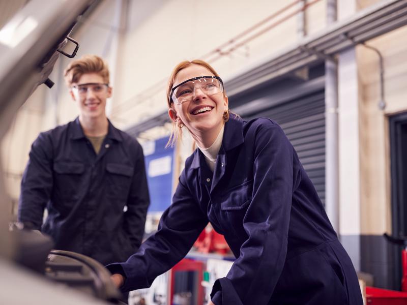 Students looking at car engine on auto mechanic apprenticeship course