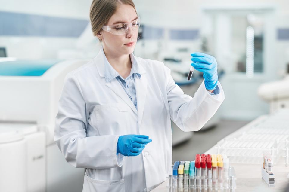 A woman in a lab coat testing samples in a lab