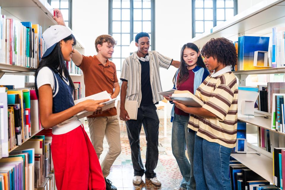 Students huddling between aisles in a library